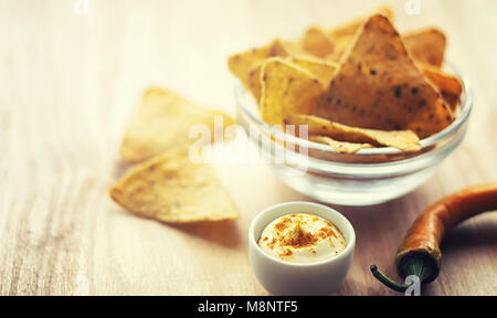 Mais Chips in der jar. Traditionelle Snack für Bier mexikanische Nachos. Nachos mit Gewürzen und Pfeffer auf Holztisch. Stockfoto