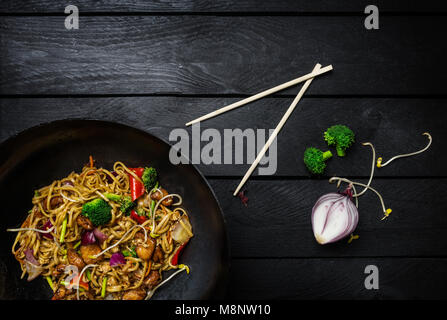 Stir Fry Nudeln in Traditioneller Chinesischer Wok, Essstäbchen und Zutaten. Platz für Text. Stockfoto