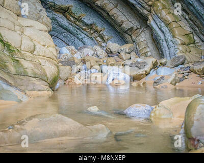 Flysh Klippen Höhleneingang im La Concha Strand in San Sebastian, Baskenland, Spanien Stockfoto