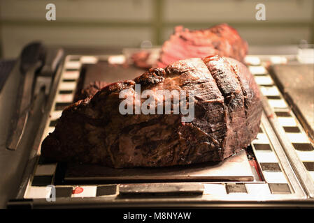 Essen mit saftigen ganze Braten gemeinsame von Rindfleisch und einen Teil geschnitzt Stockfoto