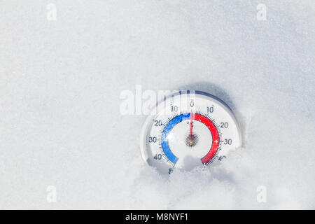 Thermometer mit Celsius in einem Schnee zeigt Null Temperatur Wetter im Frühling Konzept plaziert Stockfoto