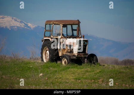 Alten Traktor im Feld mit Berg Hintergrund Stockfoto