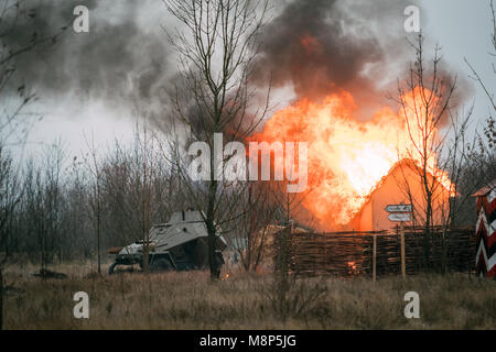 Rote Armee gepanzerten Auto verläuft in der Nähe des brennenden Gebäude. Wiederaufbau der Befreiung der Stadt Gomel, Weißrussland Stockfoto