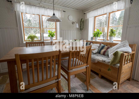 Alte Küche im Landhausstil in Schweden mit Tisch Stühle und Sofa Stockfoto