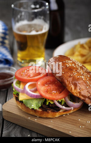 Lecker Hamburger mit Gemüse und ein Schnitzel. Sandwich mit Bier close-up Stockfoto