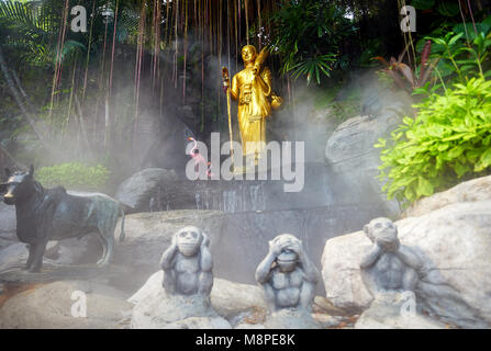 Goldene Buddha-Statue im tropischen Garten mit Wasserfall im Wat Saket goldenen Berg Tempel in Bangkok Stockfoto