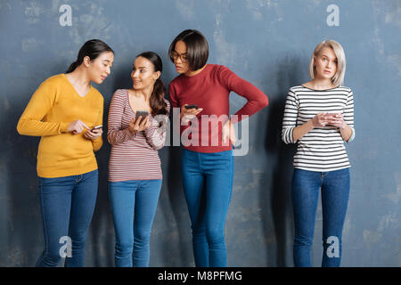 Nette junge Frauen über ihre Gadgets Stockfoto