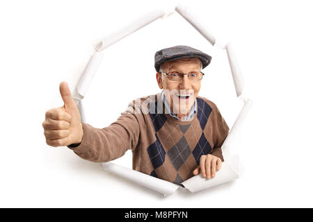 Freundliche senior Brechen durch Papier und einen Daumen nach oben anmelden Stockfoto