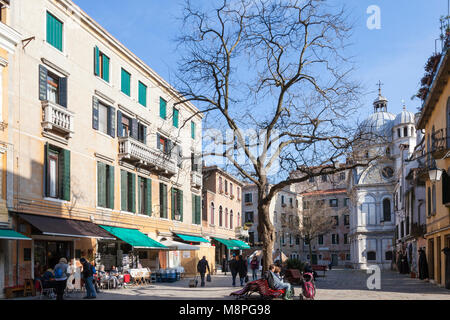 Campo Santa Maria Nova, Cannaregio, Venice, Veneto, Italien im Winter mit Menschen sitzen genießen die Nachmittagssonne und Chiesa di Santa Maria dei Miracoli Stockfoto