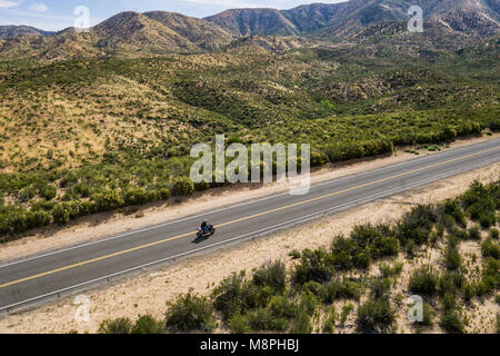 Motorrad Biker Fahrten auf der Spur einer Autobahn in der Mojave Wüste in Kalifornien. Stockfoto