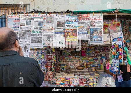 Oaxaca Oax., Mexiko - ein Mann liest die Schlagzeilen der vielen Zeitungen auf Verkauf zu einem Zeitungskiosk. Stockfoto