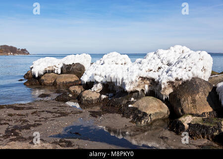 Schmelzendes eis Formationen auf Felsen an der Küste bei Skodsborg nördlich von Kopenhagen, Dänemark, auf einer frühen, sonniger Frühlingstag am Sound/Oresund nach einem langen kalten Bann von Tag und Nacht Frost und starke onshore Wind.. Stockfoto