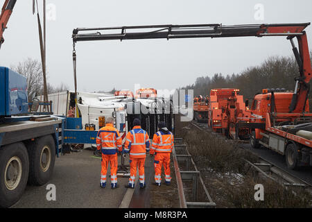 20. März, Deutschland, Boppard: Erholung der Arbeitnehmer versuchen, rechts ein Moloch mit Rindfleisch, die auf der Autobahn 61 (A61) Autobahn in der Nähe von Boppard umgeworfen. Die Autobahn musste mehrere Stunden gesperrt werden. Foto: Thomas Frey/dpa Stockfoto