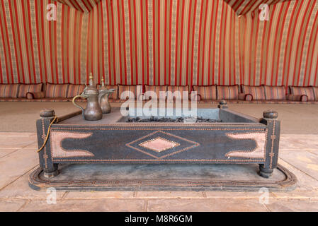 Das Innere eines großen traditionellen arabischen Zelt mit rot gemusterten Gewebe gefüttert und den Boden in die Kissen fallen zu sitzen Stockfoto