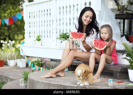 Junge Mädchen auf der Veranda des Hauses Süßigkeiten Wassermelone Stockfoto