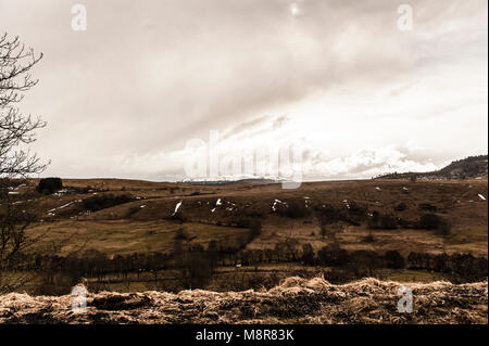 Unterwegs auf der Landstraße D3 mit den Bergen des Cantal in Auvergne, Frankreich Stockfoto