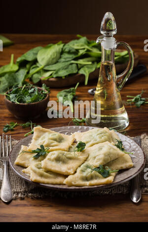 Bereit Ravioli in einer Platte, Spinat, Olivenöl in einem Topf. Stockfoto