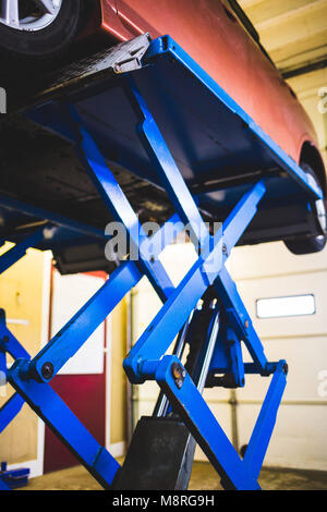 Auto in der Garage auf der Hebebühne unter Reparatur Diagnose Stockfoto