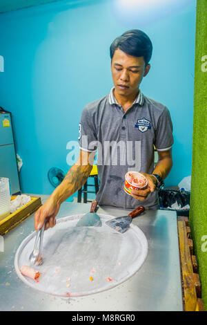 AO NANG, THAILAND - 19. FEBRUAR 2018: unbekannter Mann arbeiten an Rühren - gebratenes Eis rollt mit freeze Pan, mann Eis Dessert gemacht. Gebratenes Eis Maschine mit Stahl gekühlt Pan Stockfoto
