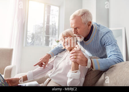 Gerne älteres Paar Kontrolle der Karte online Stockfoto