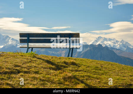 Bank in Bettmeralp in der Schweiz mit schönem Blick auf die Berge Stockfoto