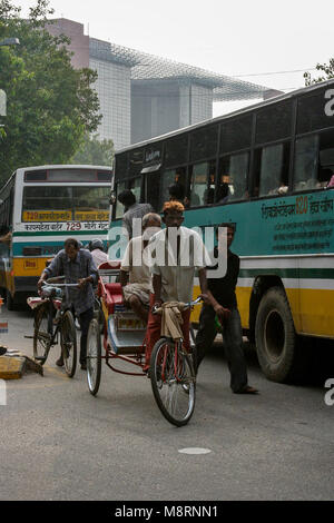 Neu Delhi, Indien: Eine indische Rikscha jongliert in einem Stau von Bussen in Neu Delhi. Stockfoto