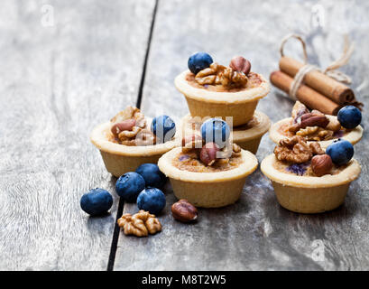 Mini Ingwer und Walnuss Kuchen mit Heidelbeeren auf hölzernen Hintergrund Stockfoto