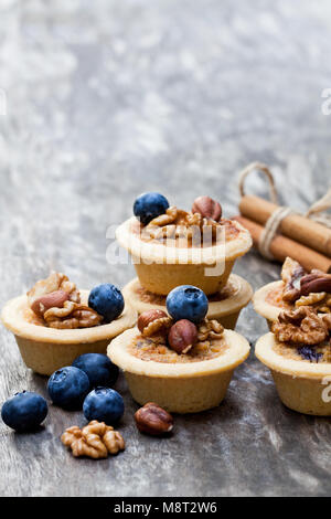 Mini Ingwer und Walnuss Kuchen mit Heidelbeeren auf hölzernen Hintergrund Stockfoto