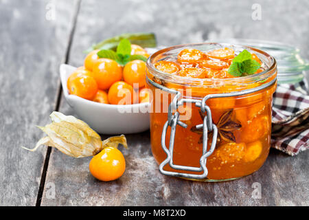 Hausgemachte physalis Marmelade im Glas auf hölzernen Tisch Stockfoto