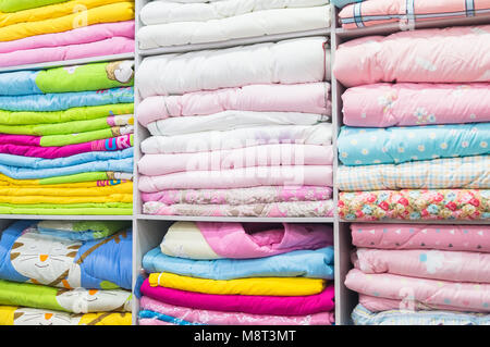 Die Bettwäsche ist schön auf den Regalen für den Verkauf in der chinesischen Kleidung Marktes angezeigt Stockfoto