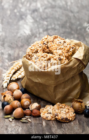 Gesund protein Granola Kekse mit Samen und Nüsse in Papiertüte auf hölzernen Tisch Stockfoto