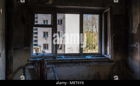 Blick durch Das zerbrochene Fenster in verlassenen Haus. Gebrochene Fenster in einem der verlassenen Gebäude in Skrunda 1. Stockfoto