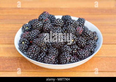 Maßstab voller Reife Brombeeren auf hölzernen Tisch Teak Stockfoto