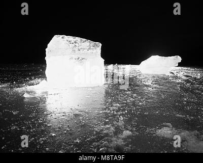 Shining faltige Oberfläche gebrochenem Eis, frische eisige Stücke auf flachen frost Boden. Bunte winter Sonnenuntergang. Stockfoto