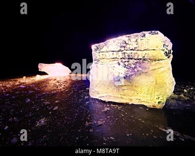 Shining faltige Oberfläche gebrochenem Eis, frische eisige Stücke auf flachen frost Boden. Bunte winter Sonnenuntergang. Stockfoto