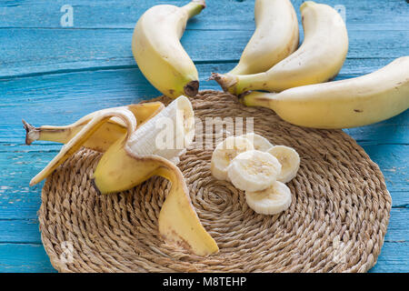 Eingestellt von Bananen in Scheiben geschnitten auf einer Platte auf Blau Holz- Hintergrund Stockfoto