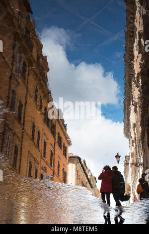 Zwei Leute in einer großen Pfütze nach einem Regenschauer, Rom, Italien wider Stockfoto