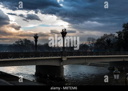 SKOPJE, MAZEDONIEN - Stadtzentrum mit Gehweg und eine Brücke über den Fluss Vardar bei Sonnenuntergang Stockfoto