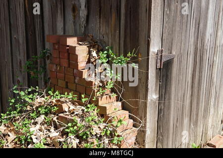 Urigen alten Bauernhof mit rostigen Scharniere, Haspen und einen Haufen Ziegelsteine verwendet. Stockfoto