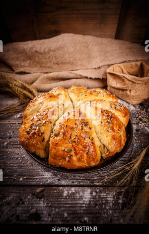 Frisch gebackenen Weizen Brötchen mit Mix aus Samen auf rustikalen Hintergrund Stockfoto