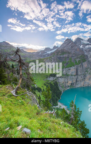 Spektakuläre Aussicht von einem hohen Felsvorsprung, Klippe von einem alpinen See bei Sonnenaufgang. Bunte Himmel, Wald und Berge Rahmen einem tiefblauen See. Die Schweiz wandern. Stockfoto