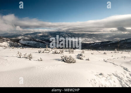 Beskid Zywiecki Bergen von Wanderweg in der Nähe von Magurka Wislanska Hügel in Beskid Slaski bergen in Polen im Winter mit Schnee und blauer Himmel Stockfoto