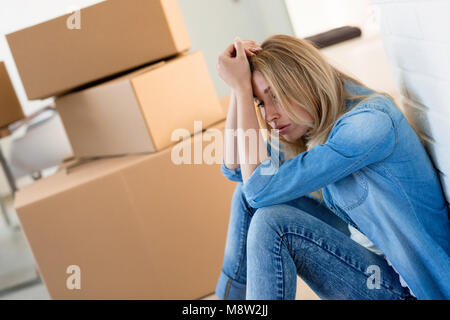 Müde Frau erschöpft beim Umzug in neues Zuhause Stockfoto