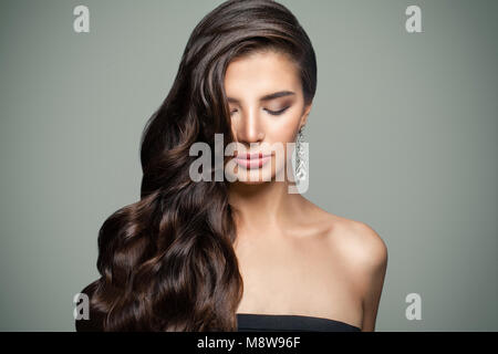 Brünette Frau mit langen Gesunden gewelltes Haar und Make-up. Dunkles Haar weiblichen Modell. Augen geschlossen Stockfoto