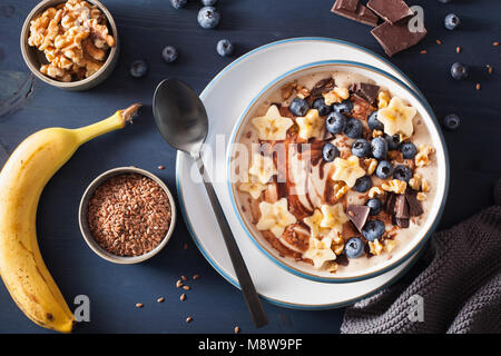 Gesund Bananen smoothie Schüssel mit Heidelbeere Schokolade Walnüsse Stockfoto