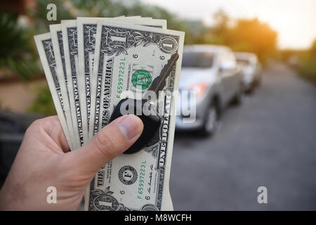 Dollar und den Schlüssel auf der Hand mit dem Auto zum Einkaufen sparen in parament Konzept Stockfoto