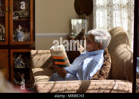 Genießen "Armut und Hungersnöte: ein Essay über den Anspruch und Entbehrungen" von Nobelpreisträger Dr. Amartya Sen, auf einen entspannten Sonntag Nachmittag. Stockfoto