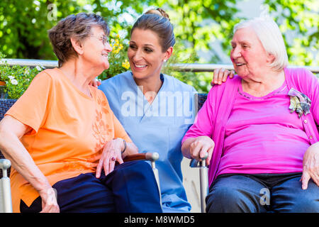 Altenpflegerin mit älteren Frauen im Ruhestand home Chat Stockfoto