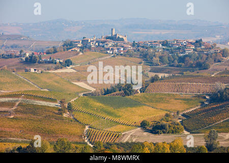 Serralunga d'Alba Stadt mit Burg auf dem Hügel von Weinbergen und Feldern im Herbst umgeben, Italien Stockfoto