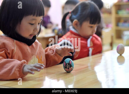 Handan. 21 Mär, 2018. Kinder spielt ein Spiel Eier am Ende zu stehen in einem Kindergarten in Handan, nördlich der chinesischen Provinz Hebei, März 21, 2018, auch den Tag der 'Chunfen'. Chunfen, was wörtlich bedeutet Frühlingspunkt oder Tagundnachtgleiche, fällt auf den Tag, wenn die Sonne genau auf die himmlischen Breitengrad von Null Grad. Credit: Hao Qunying/Xinhua/Alamy leben Nachrichten Stockfoto